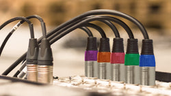 xlr cables plugged into a mixing board