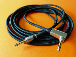 coiled up guitar cable on an orange surface