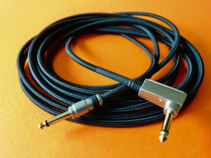 coiled up guitar cable on an orange surface